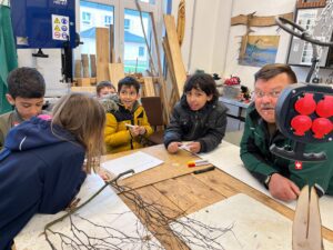 Kinder lernen beim Projekt Thinka das Schnitzen von Stöcken