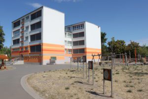 Grundschule Bad Frankenhausen. Zwei große verbundene Gebäude in weiß und orange.