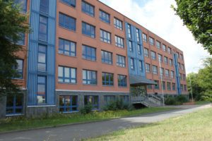 Grundschule Östertal. Großes orange, blaues Gebäude.