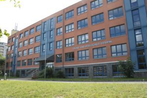 Realschule Östertal. Großes orange, blaues Gebäude.