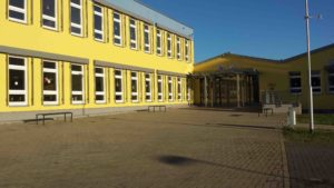 Realschule Roßleben. Großes gelbes Gebäude mit flachem Anbau.